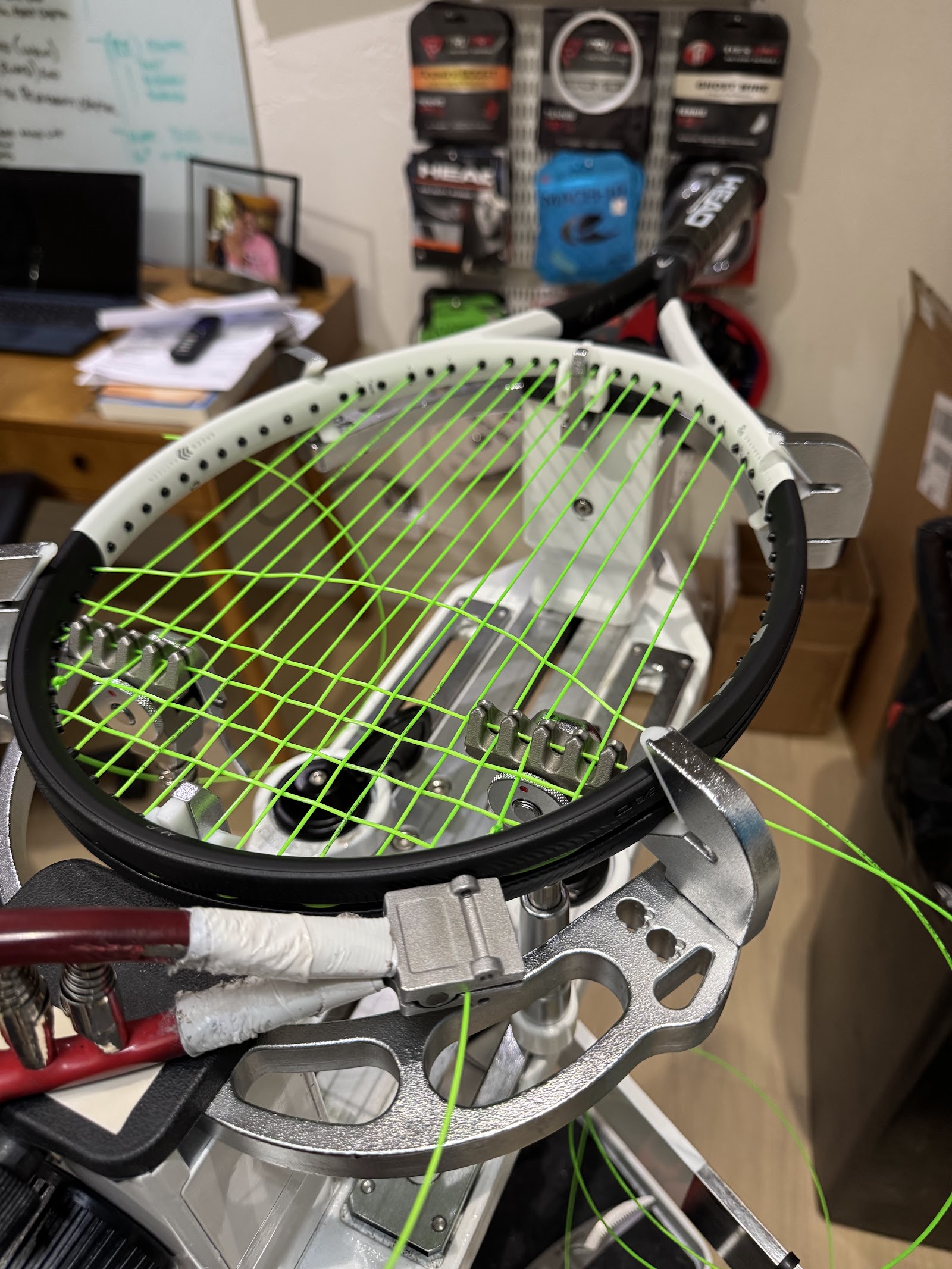 A racquet being strung on the workshop machine